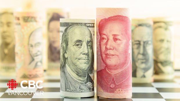 Image shows rolls of US dollar notes and Chinese Yuan notes next to each other.