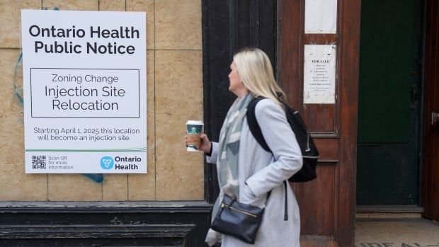 Posters appear next to a doorway in Toronto, on Monday November 25, 2024, to highlight opposition to the Ontario Government's proposed closure of supervised consumption sites. Advocates say that the closure of consumption sites will lead to unsupervised consumption in open public spaces. THE CANADIAN PRESS/Chris Young