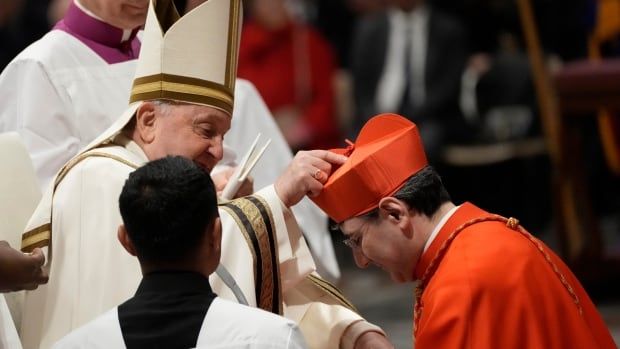 The Pope places a biretta hat on an archbishop to officially make him a cardinal.