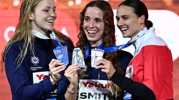 From left: American swimmers Katharine Berkoff and Regan Smith stand alongside Canada's Kylie Masse after the women’s 50-metre backstroke final at the world short course championships in Budapest, Hungary on Dec. 13, 2024.