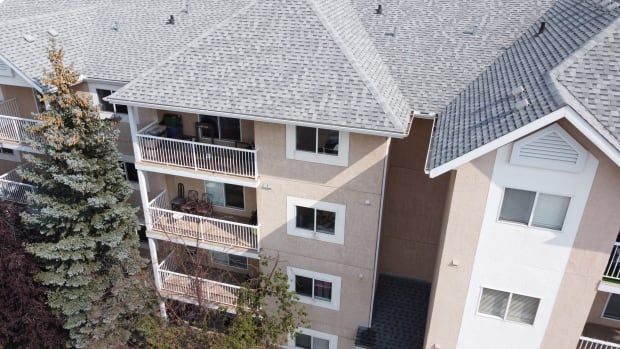 An overhead shot of a series of condo balconies. The building is a light beige trimmed in white. 