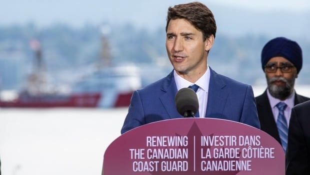 A white man delivers a news conference at a podium marked 'Renewing the Canadian Coast Guard'.