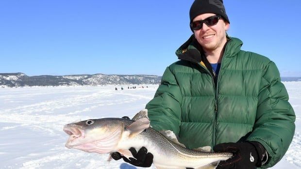 A man holds up a fish