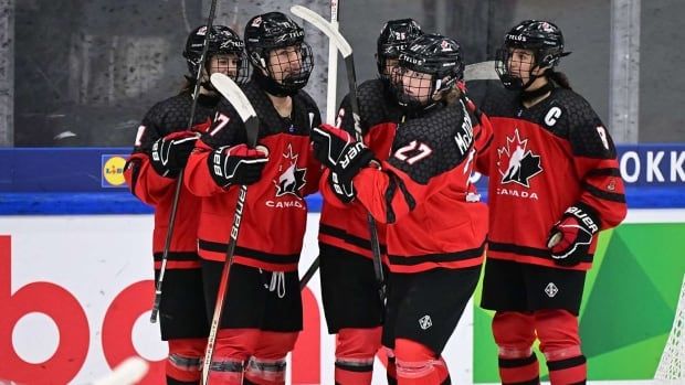 Hockey players wearing Canadian jerseys celebrate.