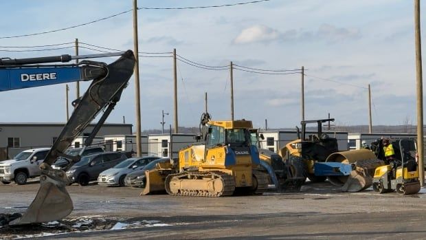 A site with trucks and white square tiny homes can be seen.