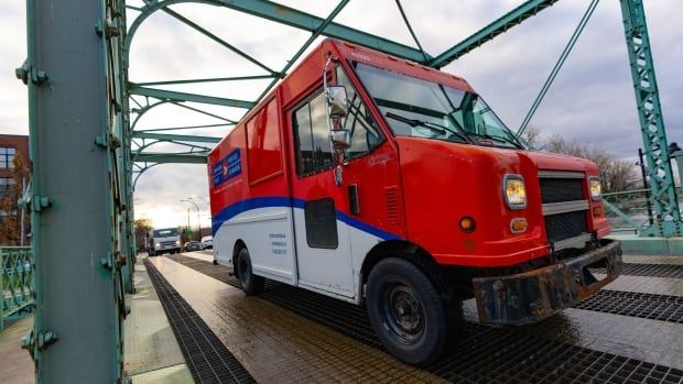 A Canada Post truck is seen on a road in Montreal on Tuesday, Dec.17, 2024. Canada Post is resuming operations after a month-long strike by more than 55,000 postal workers left letters and parcels in limbo.THE CANADIAN PRESS/Christinne Muschi