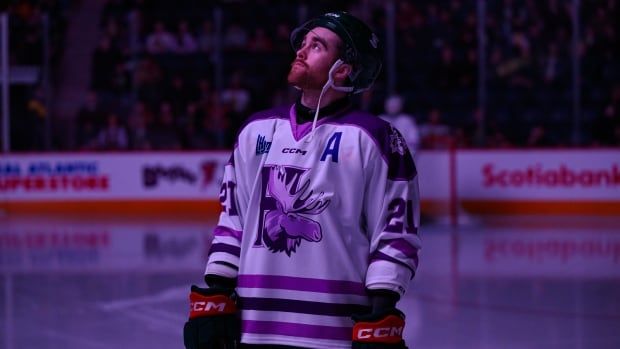 A hockey player is shown looking up during a pregame ceremony.