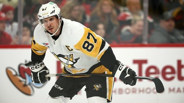 A male hockey player looks on during a hockey game.