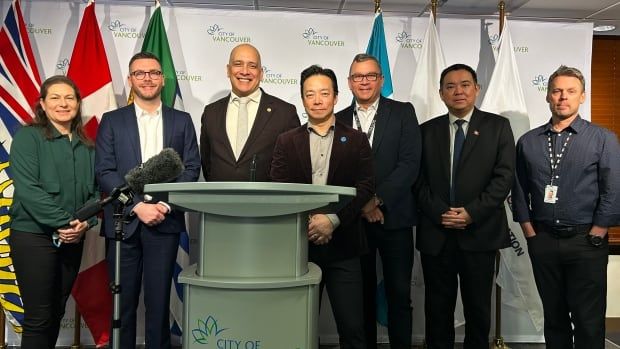 A group of politicians stand on a stage.