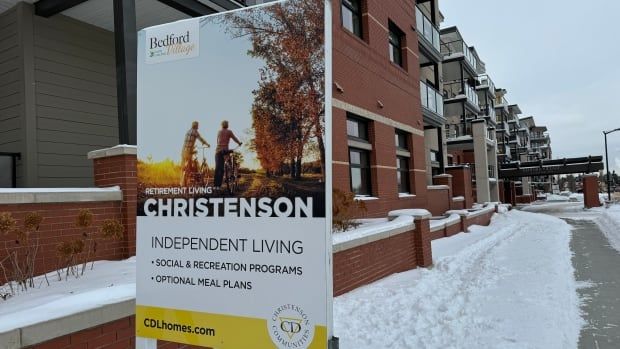 A view of a sign that says "Christenson" outside an apartment building in the winter