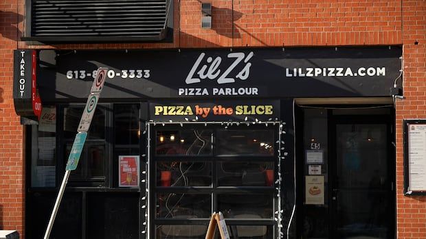 the front of a pizza parlour with black awnings saying Lil Z's Pizza Parlour