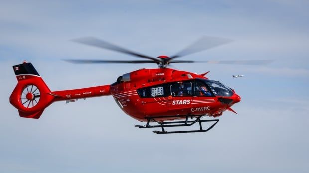 A red helicopter with white lettering reading "STARS" flies in the air.