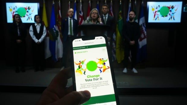 The Green Party website is viewed on a cell phone as the Green Party unveils their new branding during a press conference on Parliament Hill on Tuesday, Feb. 18, 2025. THE CANADIAN PRESS/Sean Kilpatrick