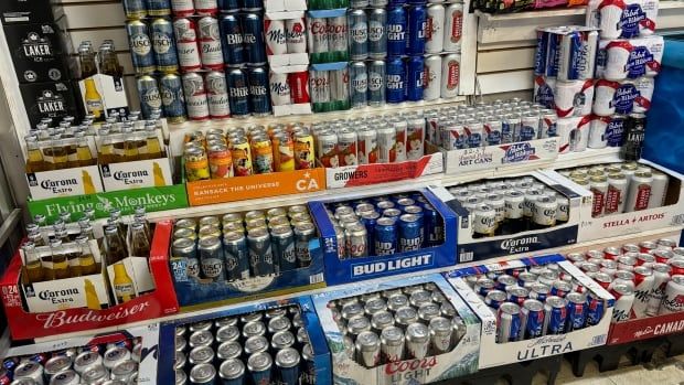 Stacked cases of various brands of beer in cans. 