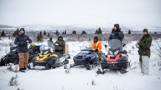 A group of people on snowmobiles.