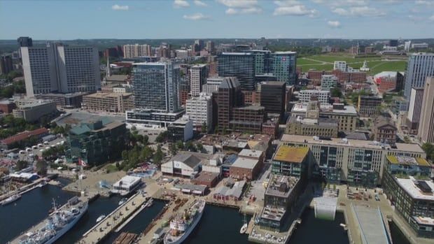 An aerial photo shows many buildings and part of a waterfront in a city's downtown area.