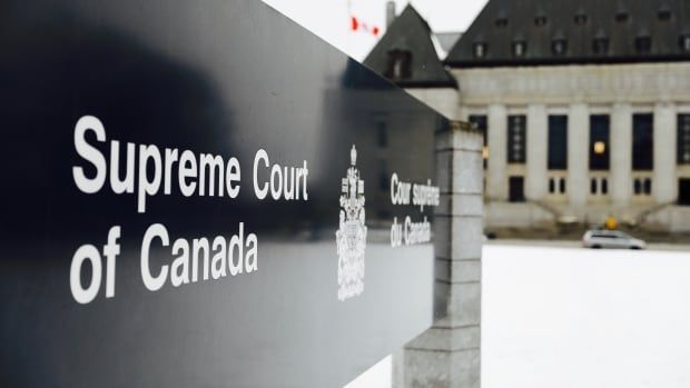 An exterior shot of a courthouse building and a sign for the Supreme Court of Canada. 