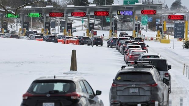 A line of cars waiting at a border crossing.