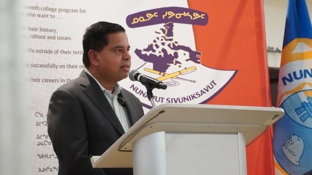 Man stands in front of a podium and speaks