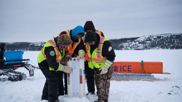 Members of SmartICE putting the equipment into the ice. 