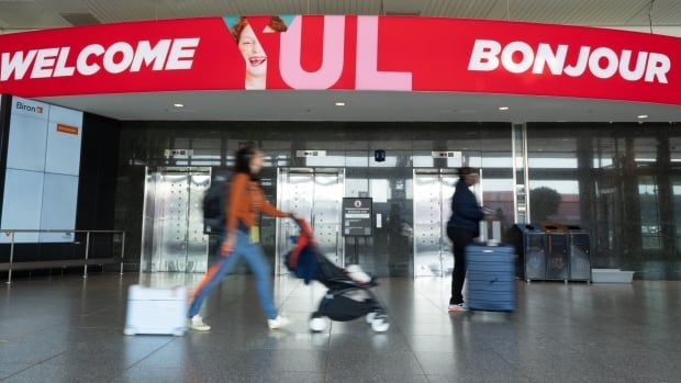 People walk through an airport.