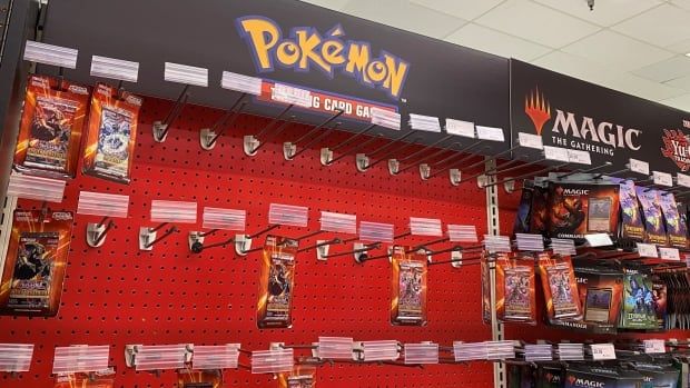 Store shelves with a Pokemon banner above it, but most of the Pokemon card packs sold out.