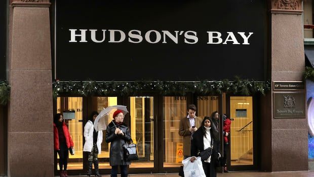 People stand outside a Hudson's Bay store.