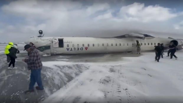 Passengers escape from a Delta plane following a crash at Pearson airport on Monday. The airport's president now says that an investigation into what happened has begun. 