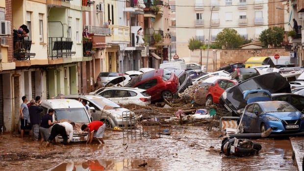 Several cars are shown piled up in a narrow laneway in an urban setting.