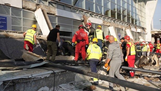 Rescue service workers inspect the rubble left behind after a roof collapse.