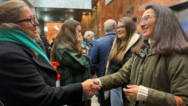 two women shaking hands