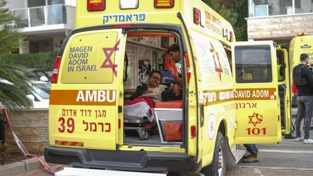 A wounded person is treated by a paramedic inside an ambulance.