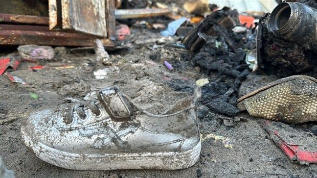 A toddler's shoe, covered in dirt, sits on the ground.