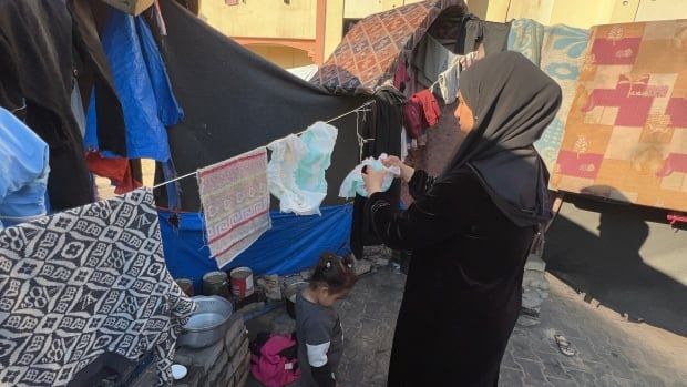 A woman hangs diapers on a line to dry 