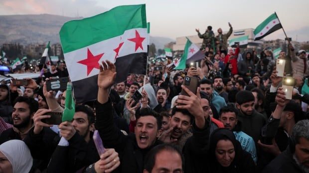 People chant while holding flags.