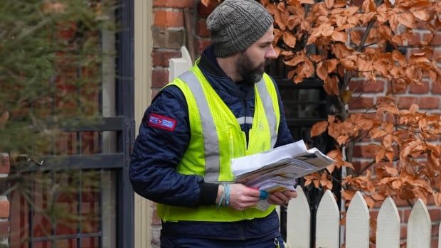 A Canada Post letter carrier delivers mail in Toronto, Tuesday, Dec. 17, 2024. Canada Post is resuming operations after a month-long strike by more than 55,000 postal workers. THE CANADIAN PRESS/Chris Young