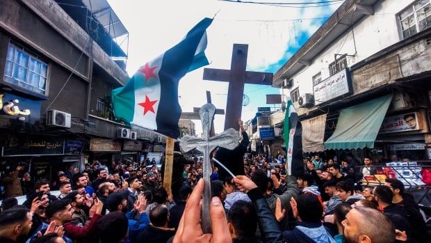 Christian Syrians lift crosses and independence-era flags at rally.