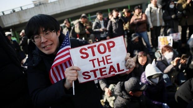 A protester holds up a sign that reads, 'stop the steal,' during a rally.