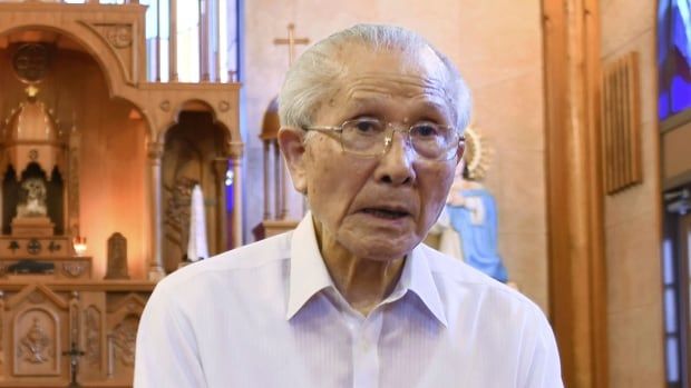 An elderly man sits in a church.