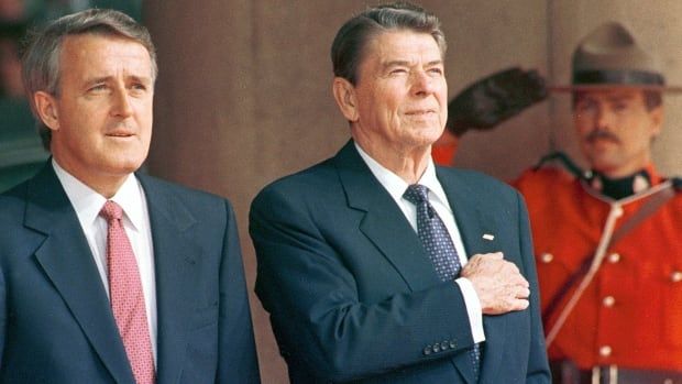 Brian Mulroney, Ronald Reagan, and a Mountie are seen standing alongside one another, at a G7 summit in Toronto in 1988.