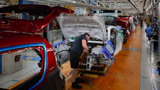 An employee at the Stellantis Windsor Assembly Plant works on the line assembling a vehicle inside of the region's largest employer. 