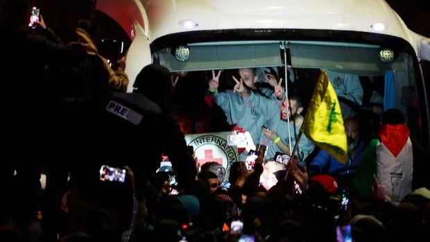 People inside a bus gesture to people gathered outside the vehicle.