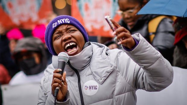 A woman speaks passionately into a microphone.