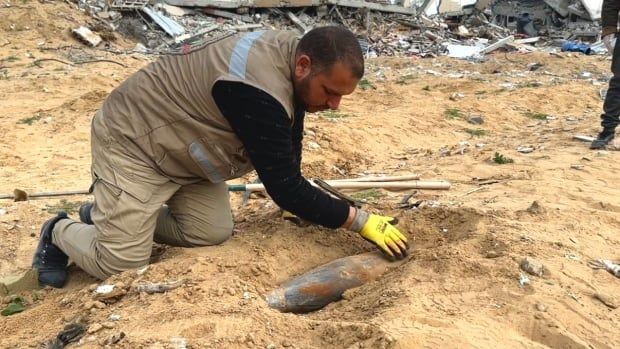 A man digs up an unexploded ordnance.