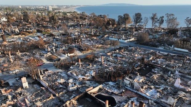 From an elevated view, lots of land are shown, with charred remains and debris after fires. The lots are located near a shoreline, with water visible.