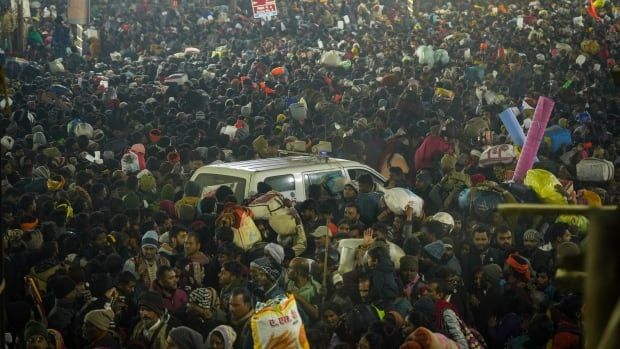 An ambulance tries to move through a very large crowd of people at a festival in Praygraj, India, on Wednesday.