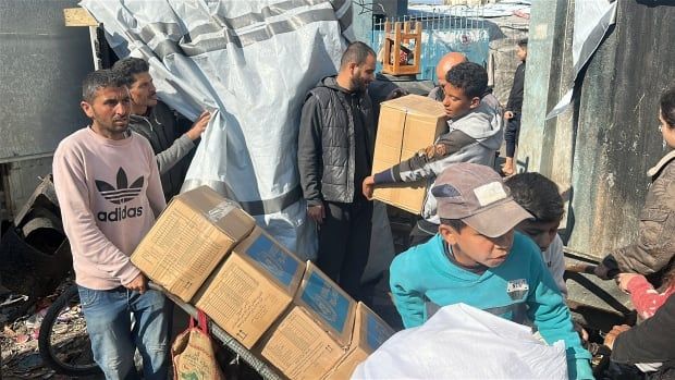 People carry boxes of aid.