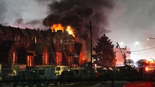 Fire and smoke are seen rising behind homes in Philadelphia following a plane crash.