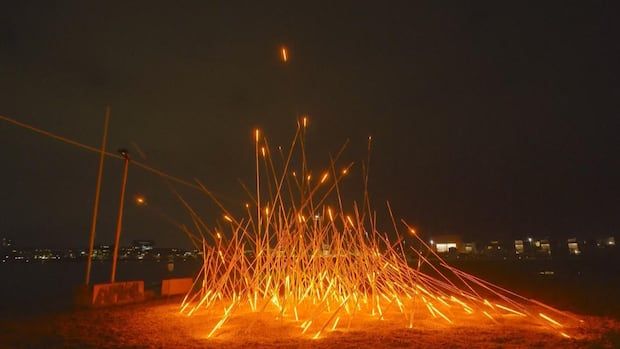 A light installation heavily resembles a blazing fire, with long, flexible tubes slowly pulsing an orange glow.