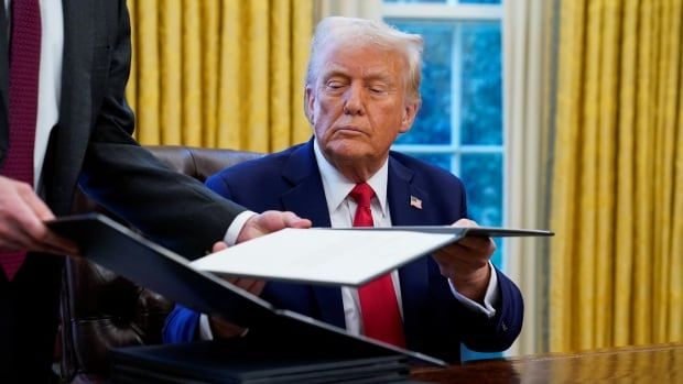 Trump receives document to sign at his desk